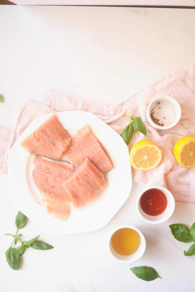 ingredients for honey sriracha salmon with basil include salmon fillets, honey, sriracha, fresh lemon, salt and pepper and freshly harvested basil leaves