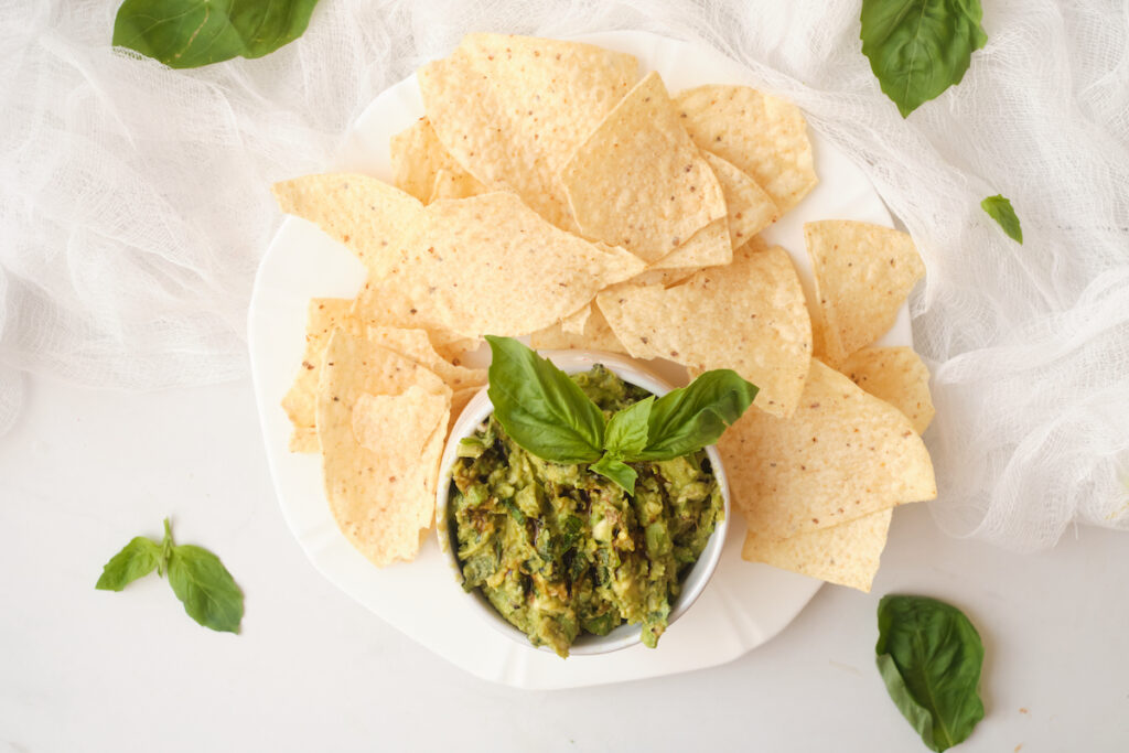 basil guacamole in a bowl with tortilla chips