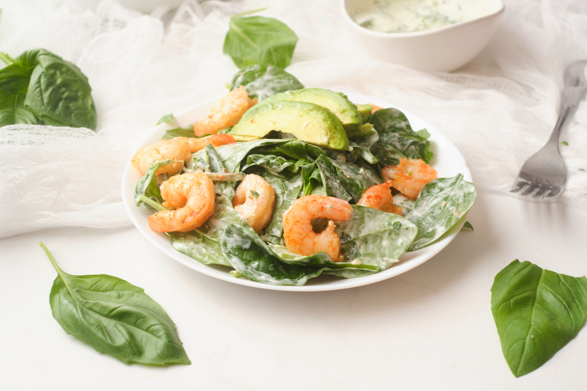 A plate of fresh chilli shrimp and avocado salad with basil green goddess dressing