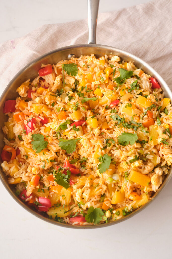 A pan full of thai pineapple fried rice with basil