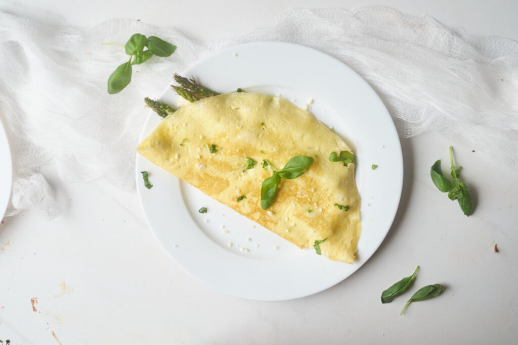 Asparagus omelet with goat cheese and basil on a plate