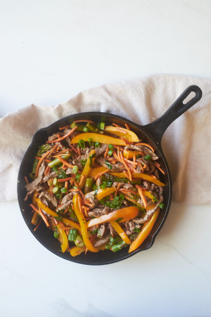 veggie honey ginger beef and basil stirfry in a cast iron pan