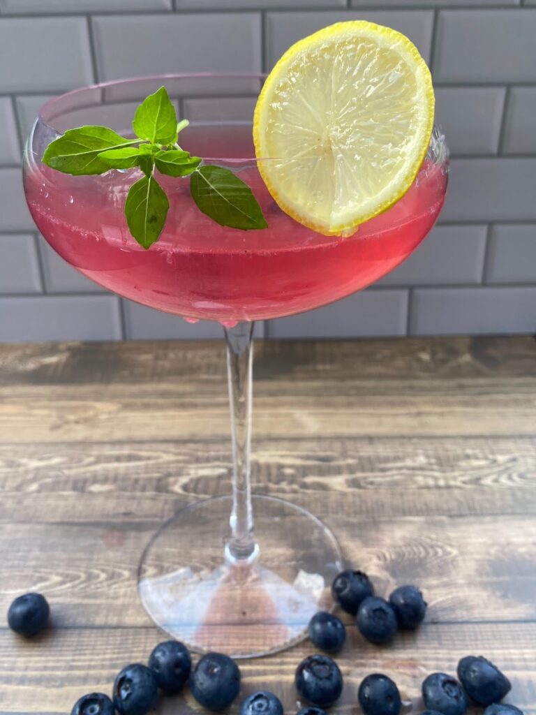 a colorful basil blueberry vodka lemonade cocktail made from blueberry infused vodka